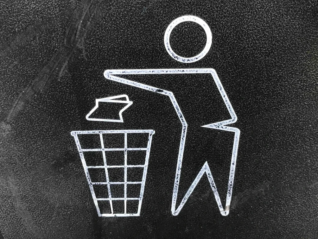 A figure dropping litter to the bin
